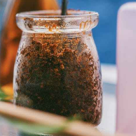 selective focus photography of clear glass jar with brown powder